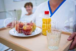 Mid section of nurse holding a breakfast