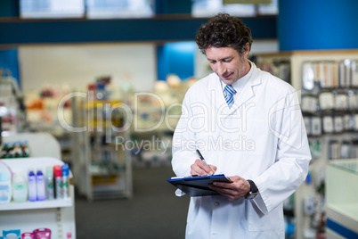 Pharmacist writing on clipboard