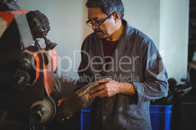 Shoemaker polishing a shoe with machine
