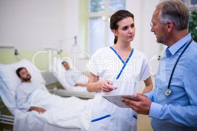 Doctor and nurse discussing over digital tablet