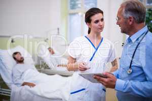 Doctor and nurse discussing over digital tablet