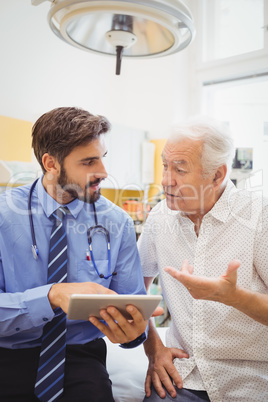 Doctor discussing with patient over digital tablet