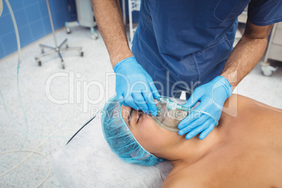 Male surgeon putting an oxygen mask on patient