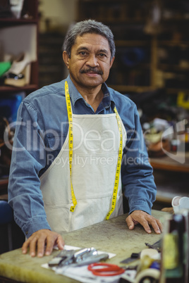 Shoemaker standing in workshop