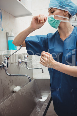 Female surgeon washing hands prior to operation using correct te