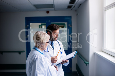 Doctors discussing over clipboard