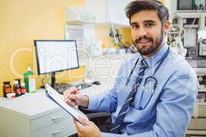 Portrait of doctor writing on a clipboard