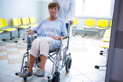 Doctor pushing senior patient on wheelchair