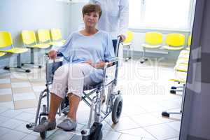 Doctor pushing senior patient on wheelchair