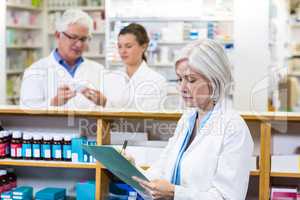 Pharmacist writing on clipboard