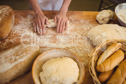 Hands of female baker kneading a dough
