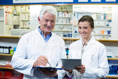 Pharmacists discussing on digital tablet and clipboard in pharma