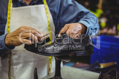 Shoemaker polishing a shoe