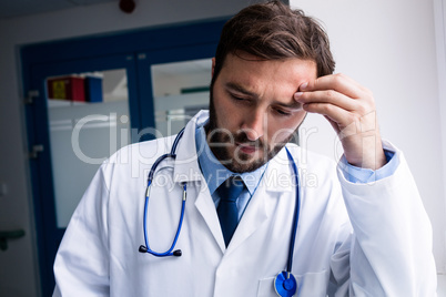 Sad doctor standing in corridor