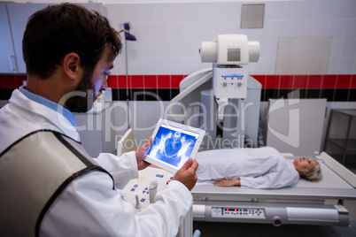 Doctor examining x-ray on digital tablet