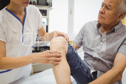 Female doctor examining patients knee