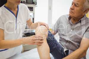 Female doctor examining patients knee