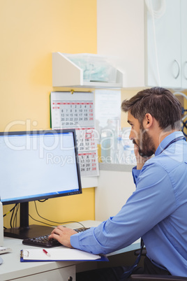 Doctor talking on phone while using computer