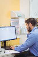 Doctor talking on phone while using computer