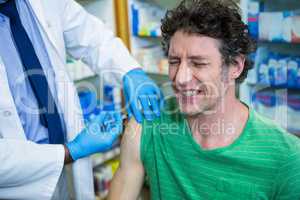 Pharmacist giving injection to patient