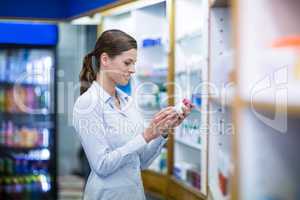 Pharmacist checking a bottle of drug