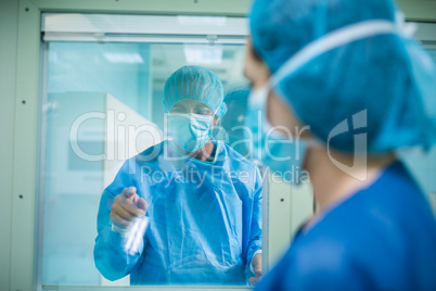 Doctor looking through a glass window