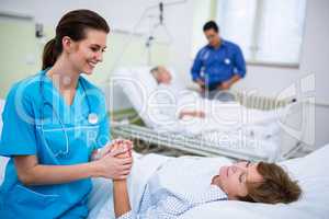 Nurse consoling a patient in hospital ward