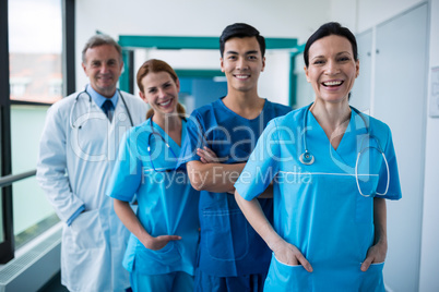 Portrait of smiling surgeons and doctors standing in corridor