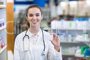 Female pharmacist holding a pill box in a pharmacy