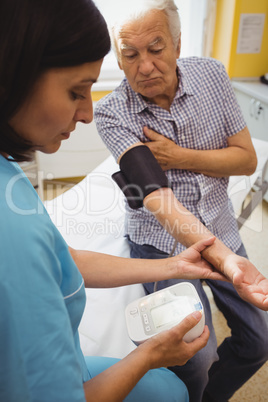 Female doctor checking blood pressure of patient