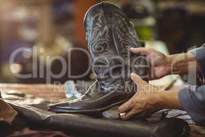 Shoemaker holding a leather boot