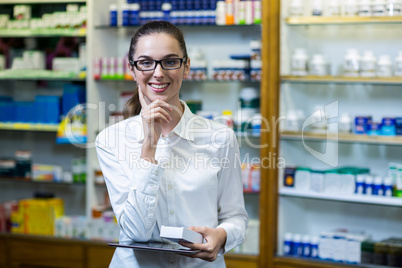 Pharmacist holding digital tablet and medicine in pharmacy