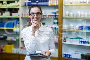 Pharmacist holding digital tablet and medicine in pharmacy