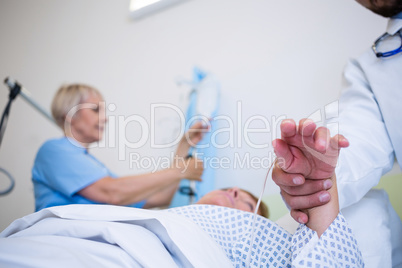 Doctor examining patients pulse