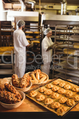 Michetta and sweet food on a table while male and female baker w