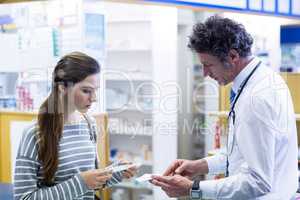 Pharmacist explaining prescriptions to customer