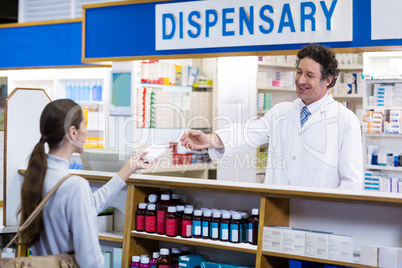 Pharmacist giving medicine box to customer