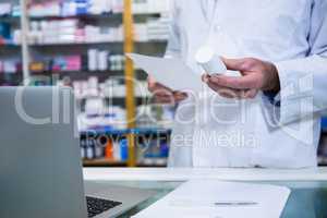 Pharmacist holding a prescription and medicine