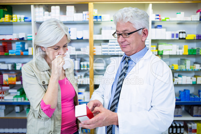 Pharmacist showing medicine to customer