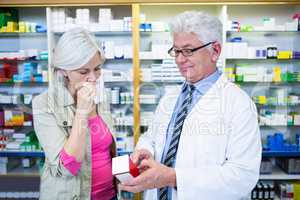 Pharmacist showing medicine to customer