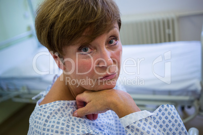 Portrait of sad senior patient sitting on a bed