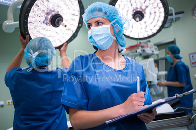 Surgeon writing on clipboard in operation room