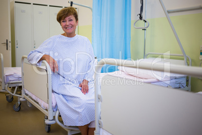 Portrait of smiling senior patient sitting on a bed