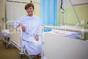 Portrait of smiling senior patient sitting on a bed