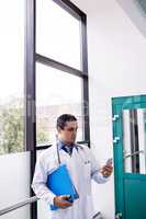 Doctor using mobile phone in corridor