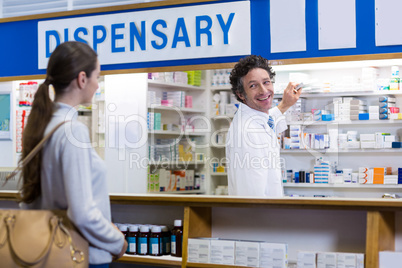 Pharmacist showing the medicine box to customer