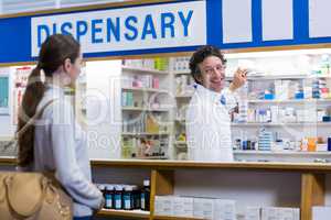 Pharmacist showing the medicine box to customer