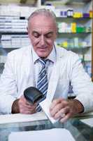 Pharmacist using barcode scanner on medicine box