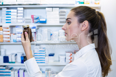 Pharmacist checking a bottle of drug