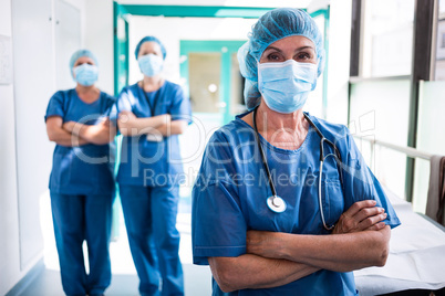 Portrait of surgeon and nurses standing with arms crossed